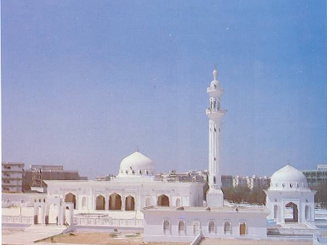 Jamia Masjid Bait ul Mukarram aerial view from the 1980s — minaret and dome against early Karachi skyline
