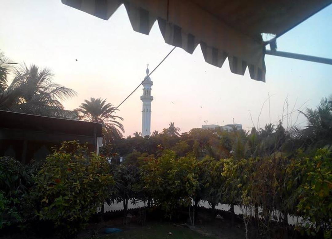 Bait ul Mukarram minaret seen through trees at dusk — archival photograph from the 1990s