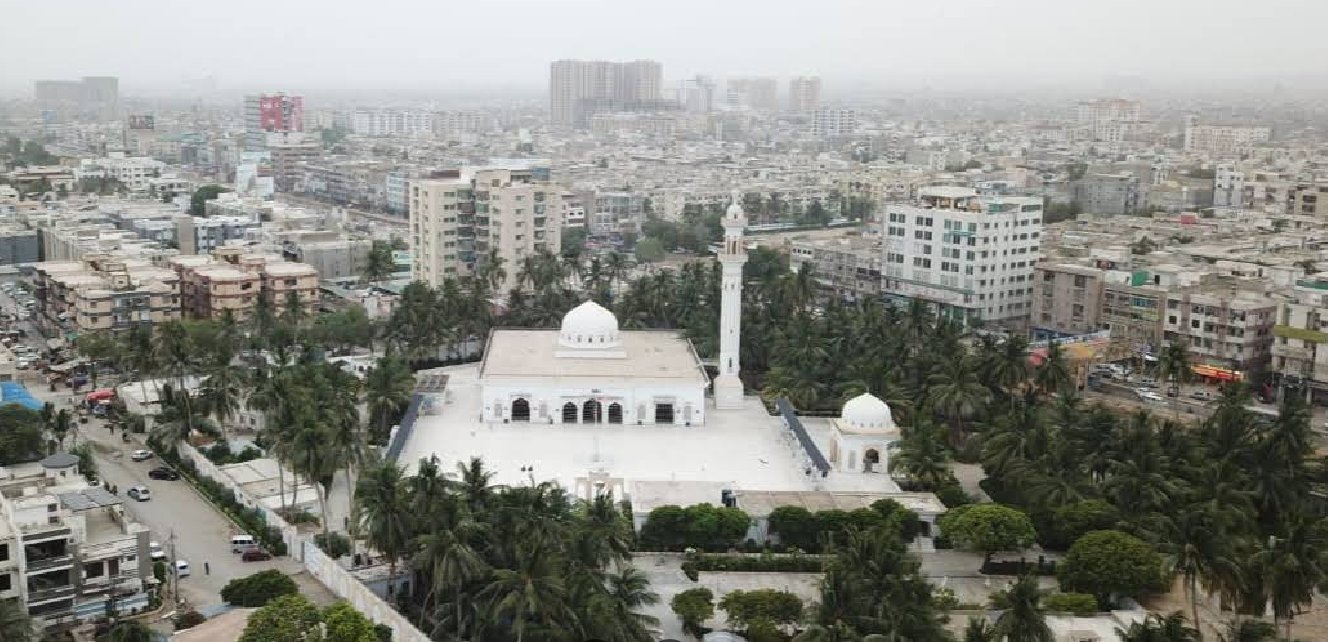 Aerial drone view of Jamia Masjid Bait ul Mukarram surrounded by palm trees in Karachi
