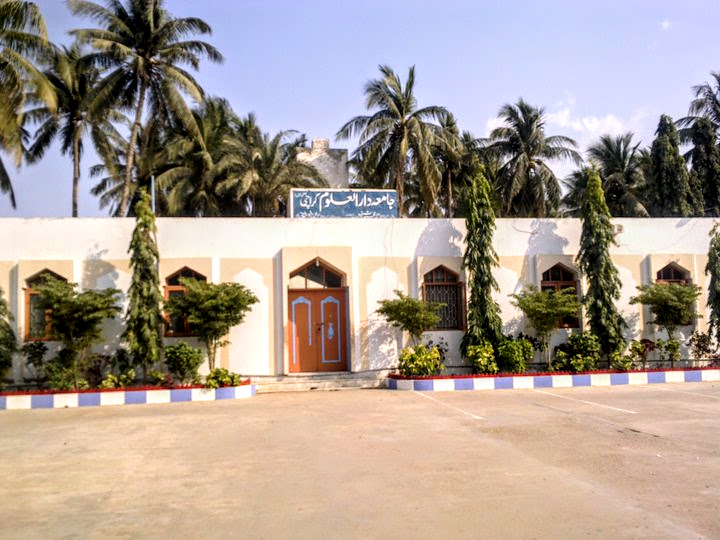 Jamia Darul Uloom Karachi branch building at Bait ul Mukarram — white building with Urdu signage and palm trees