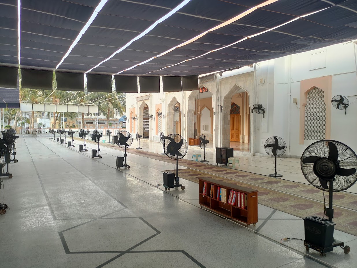 The covered sahn extension at Bait ul Mukarram — shade canopy and fans set up for summer prayers
