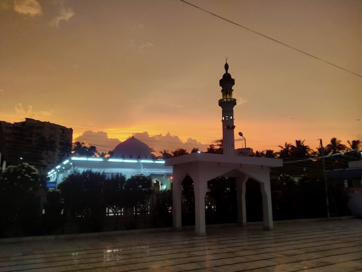 Jamia Masjid Bait ul Mukarram minaret and dome against a dramatic Karachi sunset