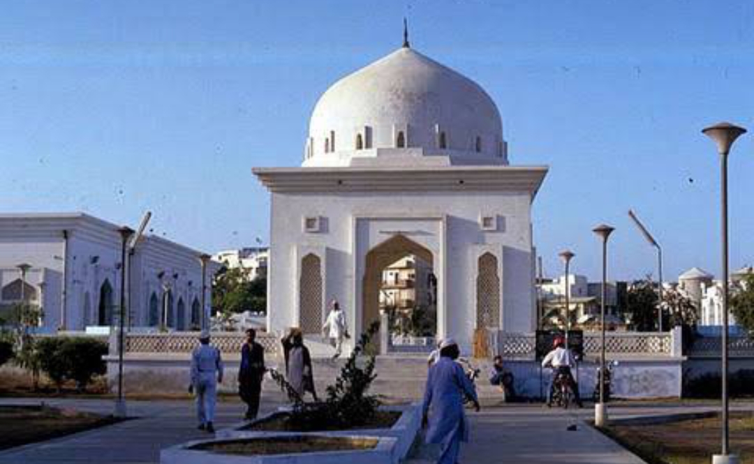 View of Bait ul Mukarram from the Hakeem Muhammad Saeed playground across University Road — boundary wall and minaret visible